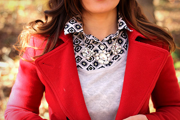 Brooke of Pumps and Push Ups wearing a mini skirt,tights, booties, red coat with button down and statement necklace