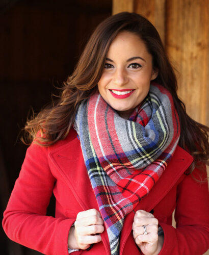 Brooke of Pumps and Push Ups wearing a black ASOS maternity dress with riding boots, tartan scarf and a red coat