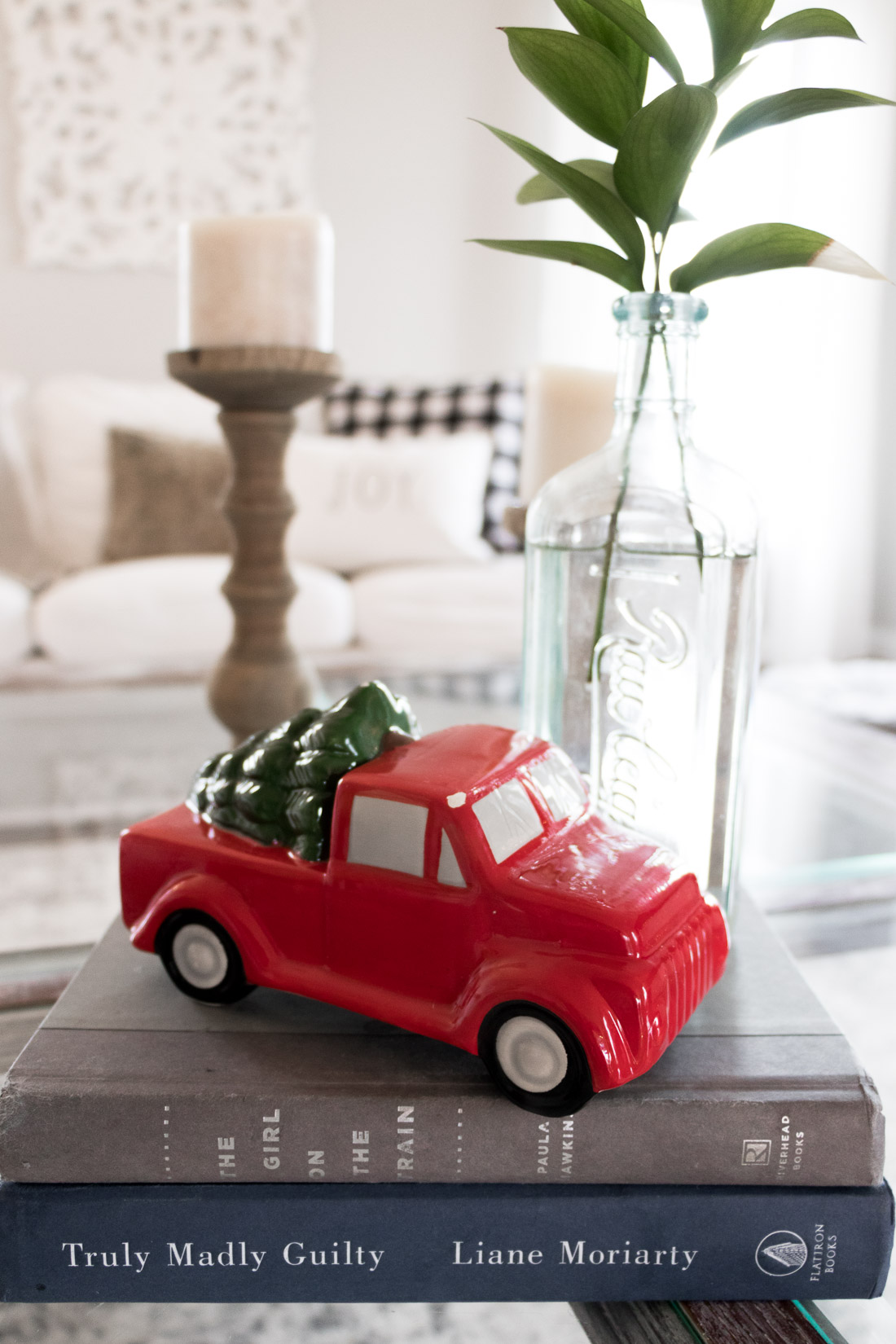 Holiday home tour. Ceramic red truck on a stack of books. Coffee table holiday decorations.