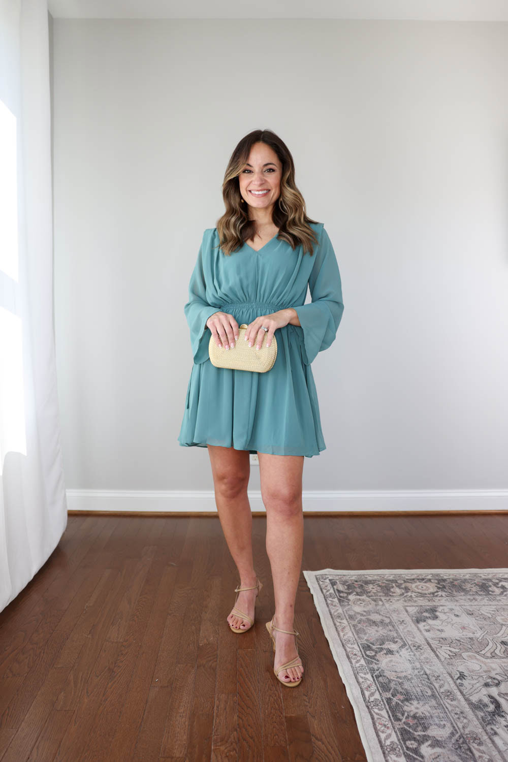 Petite style blogger Brooke of Pumps and Push-Ups wears the Chiffon Side-Tie Mini Dress from Banana Republic Factory, a fall wedding guest dress with sheer long sleeves, light chiffon overlay, full lining, and adjustable side ties for a flattering petite-friendly fit.