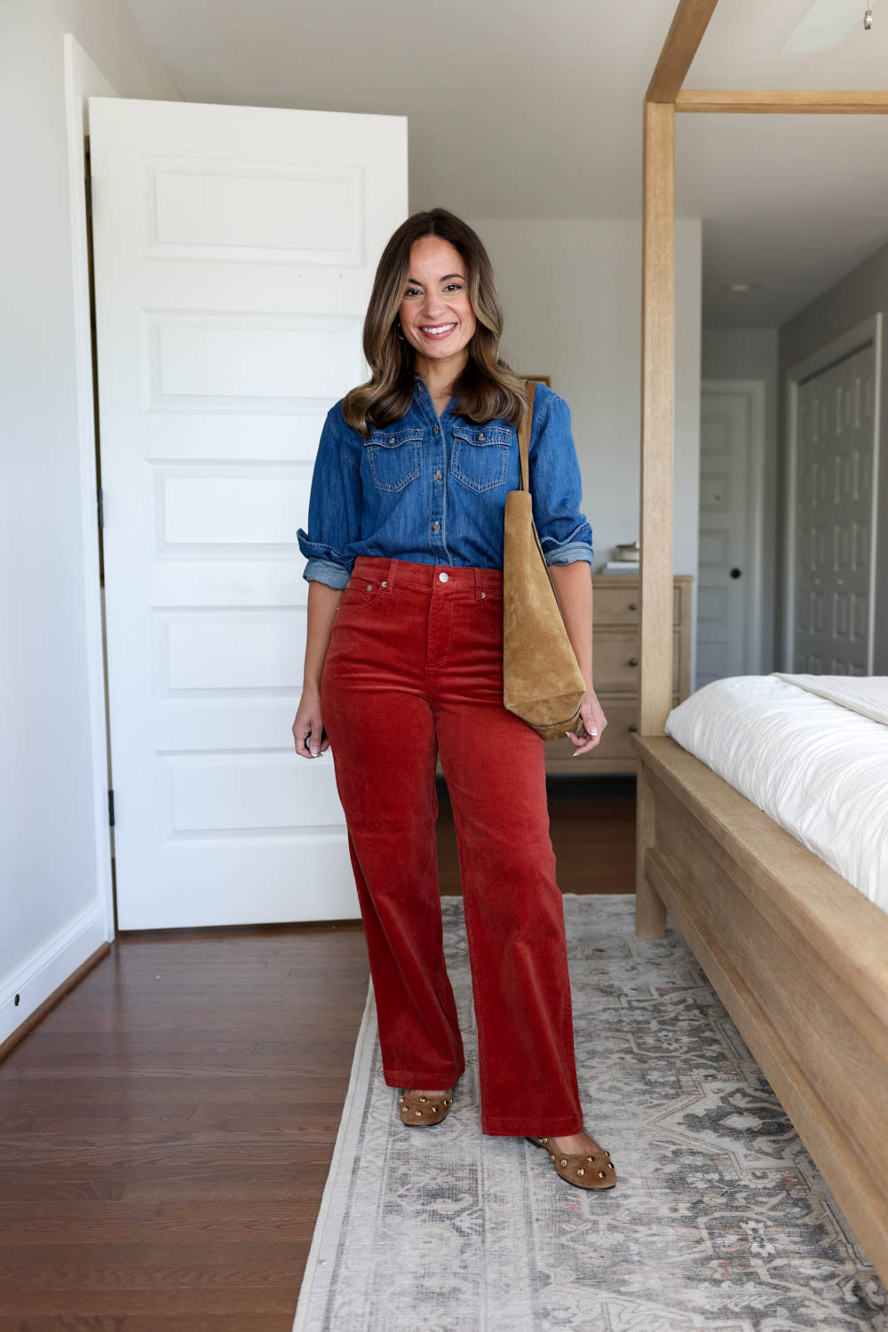 Petite outfit with rust corduroy pants, chambray top, studded ballet flats, and suede studded bag.