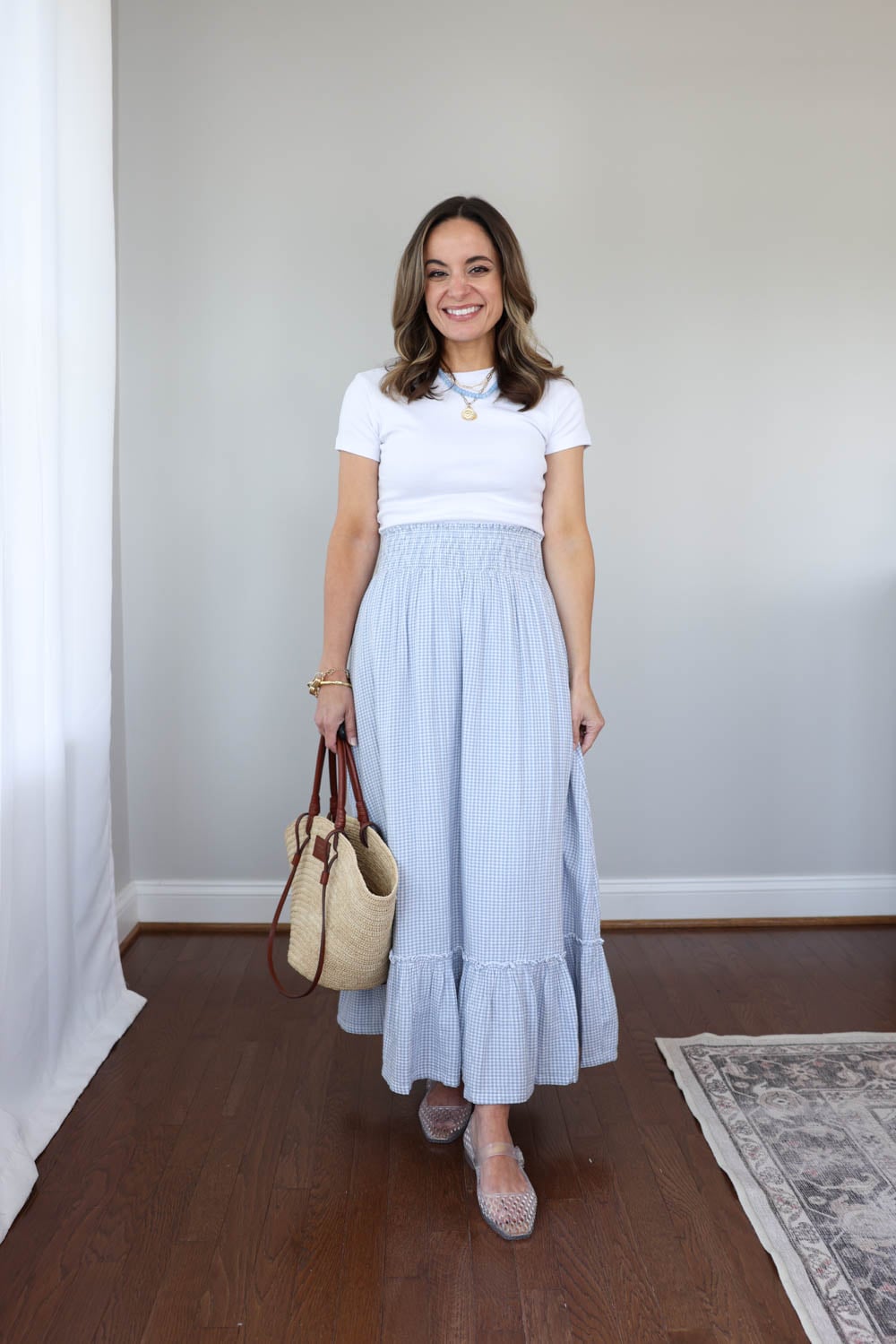 Petite summer outfit with a blue and white gingham maxi skirt from Quince, fitted t-shirt, and clear jelly shoes styled on a 4’10” frame.